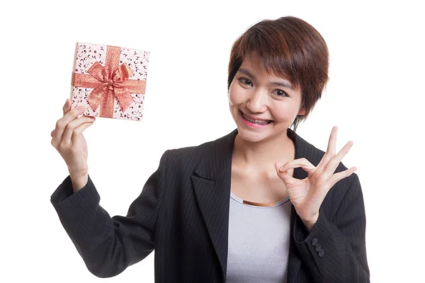 Joven mujer de negocios asiática muestran OK con una caja de regalo . —  Fotos de Stock