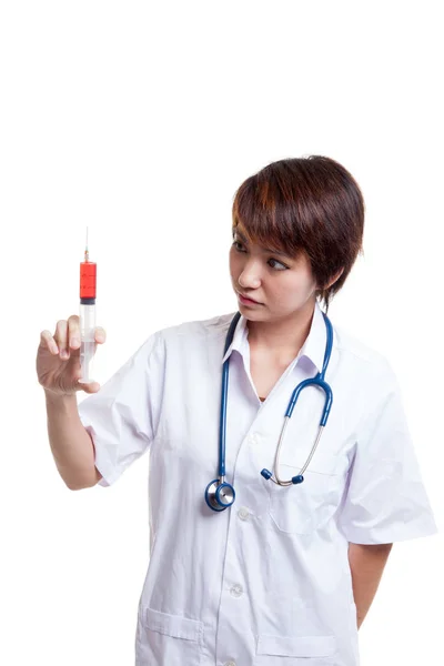 Junge asiatische Ärztin Blick auf Spritze. — Stockfoto