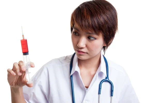 Jonge Aziatische vrouwelijke arts kijken naar spuit. — Stockfoto