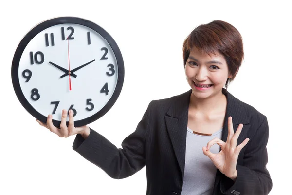 Joven mujer de negocios asiática muestran OK con un reloj . — Foto de Stock