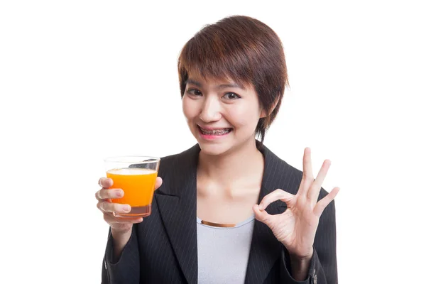 Junge asiatische Frau trinken Orangensaft zeigen ok Zeichen. — Stockfoto
