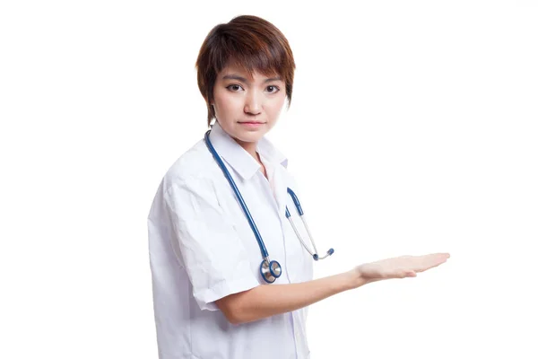 Asiatiska unga kvinnliga läkare presentera något sin vänster. — Stockfoto