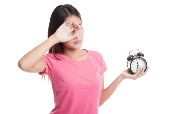 Schläfrige junge asiatische Frau mit einer Uhr am Morgen. — Stockfoto