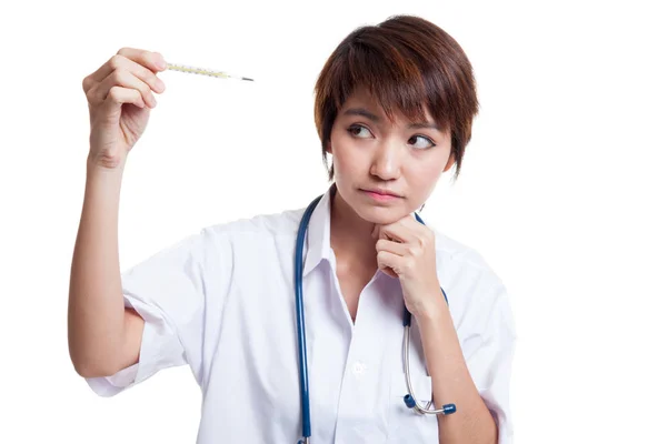 Junge asiatische Ärztin denken mit Thermometer. — Stockfoto