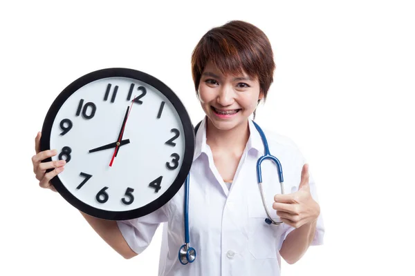 Young Asian female doctor thumbs up with a clock. — Stock Photo, Image