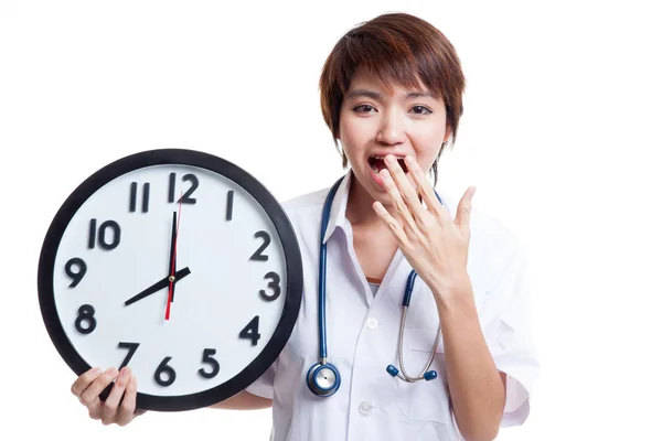 Young Asian female doctor yawn with a clock. — Stock Photo, Image