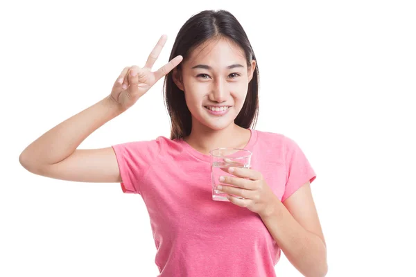 Junge Asiatin zeigt Siegeszeichen mit einem Glas Trinkwasser — Stockfoto