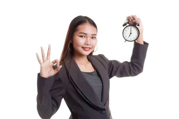 Jeune asiatique femme d'affaires montrer OK avec une horloge . — Photo