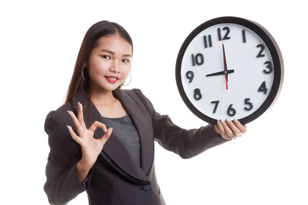 Jeune asiatique femme d'affaires montrer OK avec une horloge — Photo