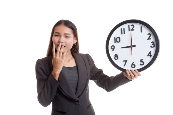 Sleepy young Asian business woman with a clock in the morning. — Stock Photo, Image