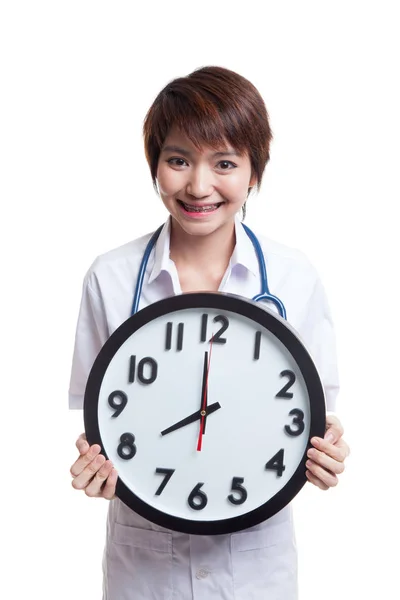 Junge asiatische Ärztin halten eine Uhr. — Stockfoto