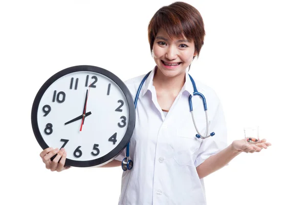 Young Asian female doctor smile with a clock and pills in hand. — Stock Photo, Image