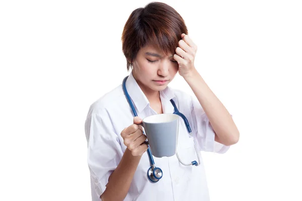 Asiatiska unga kvinnliga läkare fick huvudvärk med en kopp kaffe. — Stockfoto