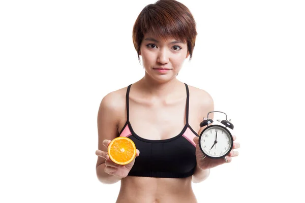 Азиатская здоровая девочка с апельсином и часами . — стоковое фото