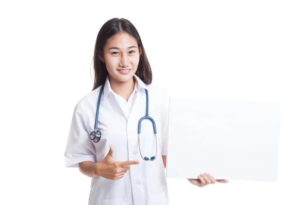 Junge asiatische Ärztin zeigt auf ein leeres Schild. — Stockfoto