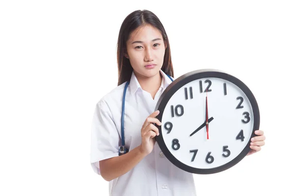 Gefrustreerd jonge Aziatische vrouwelijke arts met een klok. — Stockfoto