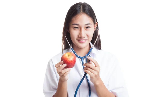 Joven asiática médico escuchando a una manzana con un estetosco —  Fotos de Stock
