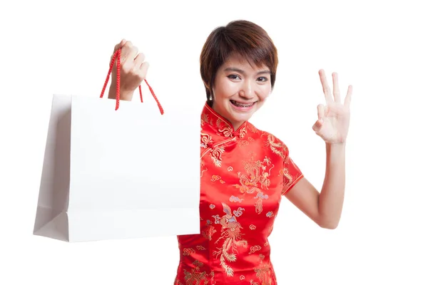 Asiatisk pige i kinesisk cheongsam kjole med indkøbspose . - Stock-foto