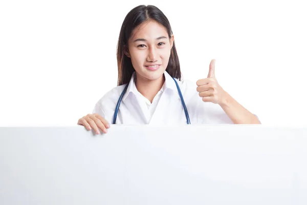 Молодая азиатская женщина-врач показывает большие пальцы вверх за пустой белый bil — стоковое фото