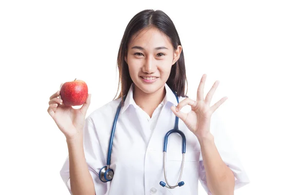Unga asiatiska kvinnliga läkare Visa Ok med äpple. — Stockfoto