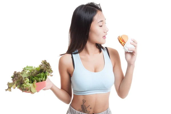 Beautiful Asian healthy girl with salad and hamburger. — Stock Photo, Image