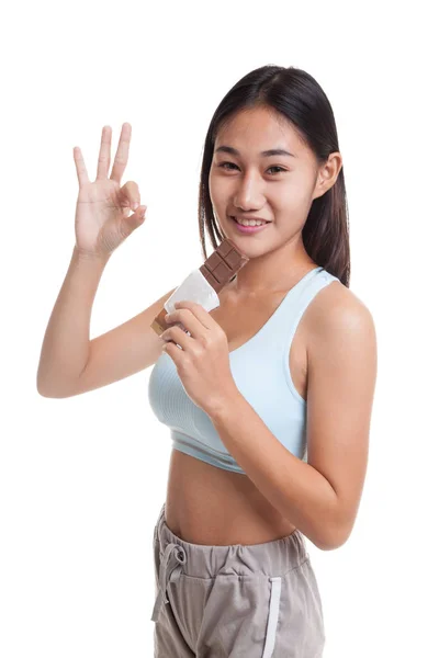 Schön gesund asiatische Mädchen zeigen ok mit Schokolade. — Stockfoto