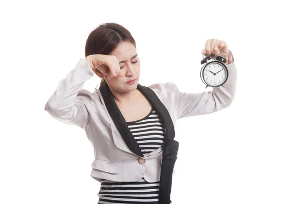 Schläfrige junge asiatische Geschäftsfrau mit einer Uhr am Morgen. — Stockfoto