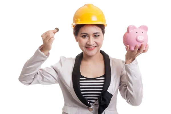 Asian engineer woman with a coin and piggy coin bank. — Stock Photo, Image