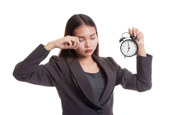 Schläfrige junge asiatische Geschäftsfrau mit einer Uhr am Morgen. — Stockfoto
