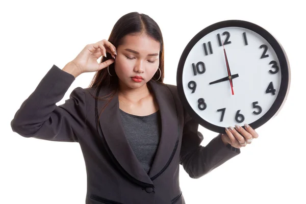 Schläfrige junge asiatische Geschäftsfrau mit einer Uhr am Morgen. — Stockfoto