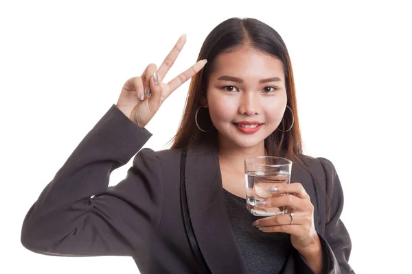 Mujer asiática joven muestra signo de victoria con un vaso de beber wat — Foto de Stock