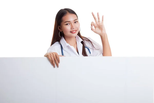 Молодая азиатка-врач показывает знак ОК за чистым белым биллем — стоковое фото