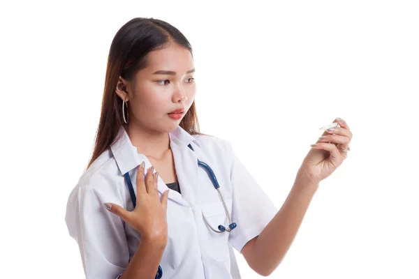 Unga asiatiska kvinnliga läkare oro titt på termometern. — Stockfoto