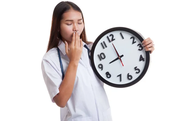 Young Asian female doctor yawn with a clock. — Stock Photo, Image