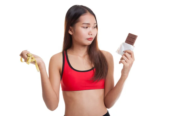 Infeliz asiática sana chica con chocolate y cinta métrica . — Foto de Stock