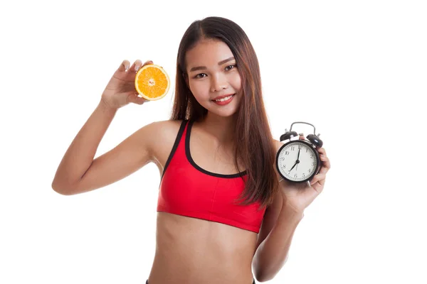 Krásná Asiatka zdravé s pomerančem a hodiny. — Stock fotografie