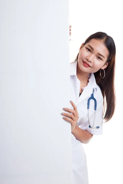 Молодая азиатская женщина-врач подглядывает из-за пустых знаков бильбоа — стоковое фото