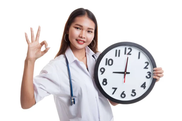 Young Asian female doctor show OK with a clock. — Stock Photo, Image