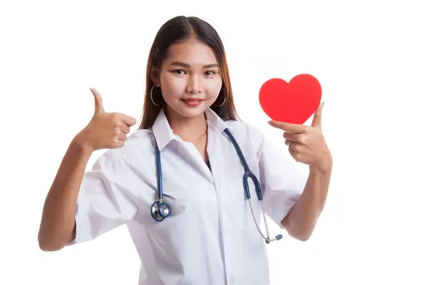 Молодая азиатка-врач показывает большие пальцы с красным сердцем . — стоковое фото