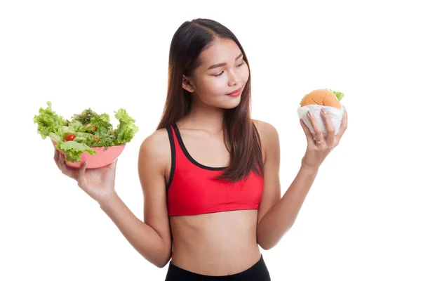 Beautiful Asian healthy girl with salad and hamburger. — Stock Photo, Image