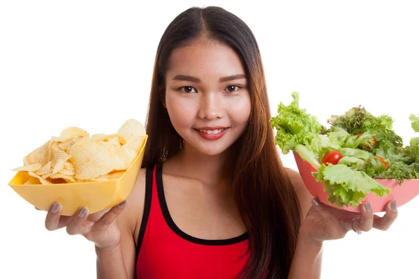 Mooie Aziatische gezond meisje salade en aardappels, chips. — Stockfoto