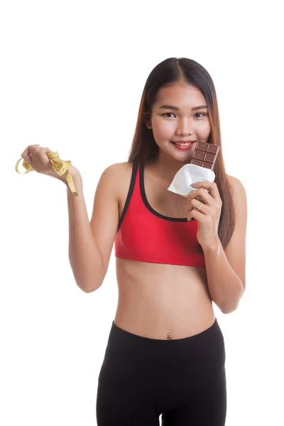 Beautiful Asian healthy girl with chocolate and measuring tape. — Stock Photo, Image