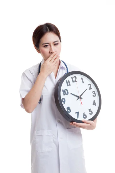 Jeune asiatique femme médecin bâiller avec une horloge . — Photo