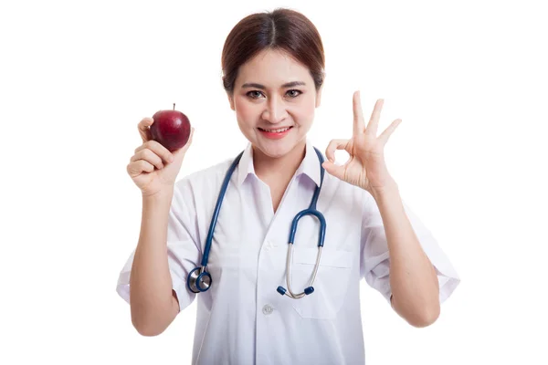 Junge asiatische weibliche Arzt zeigen ok mit Apfel. — Stockfoto
