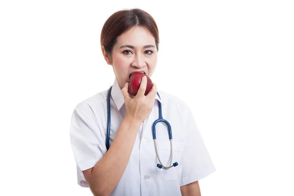 Junge asiatische Ärztin essen Apfel. — Stockfoto