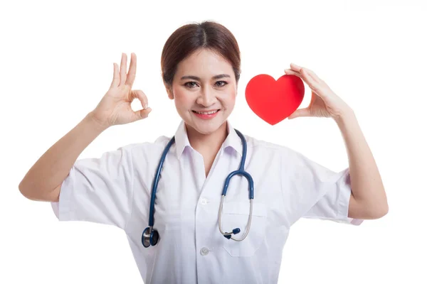 Молодая азиатка-врач показывает знак ОК с красным сердцем . — стоковое фото