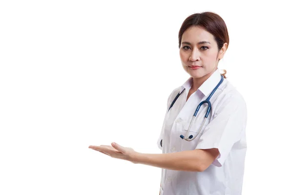 Aziatische jonge vrouwelijke arts voorstellen iets op haar links. — Stockfoto