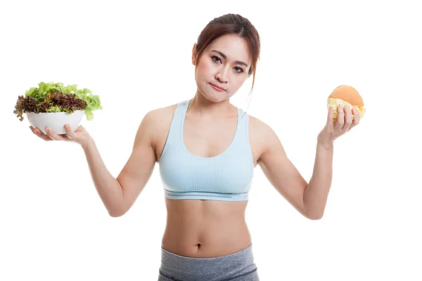 Beautiful Asian healthy girl with salad and hamburger. — Stock Photo, Image