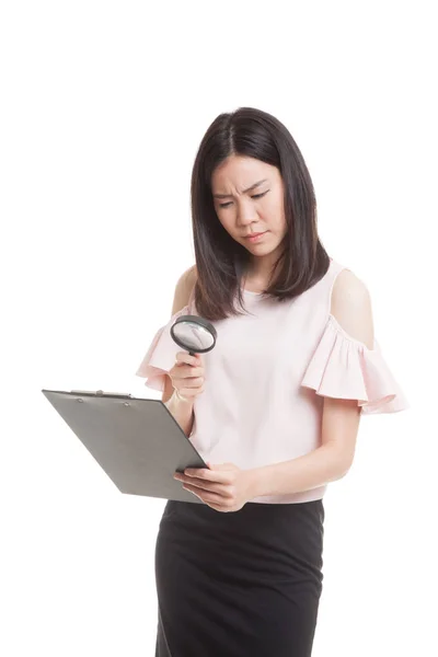 Unga asiatiska affärskvinna med ett förstoringsglas kontrollrapporten. — Stockfoto
