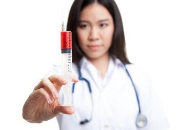 Genç Asyalı kadın doktor gülümseme tutun şırınga odak şırınga.